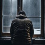 Mann schaut aus Fenster